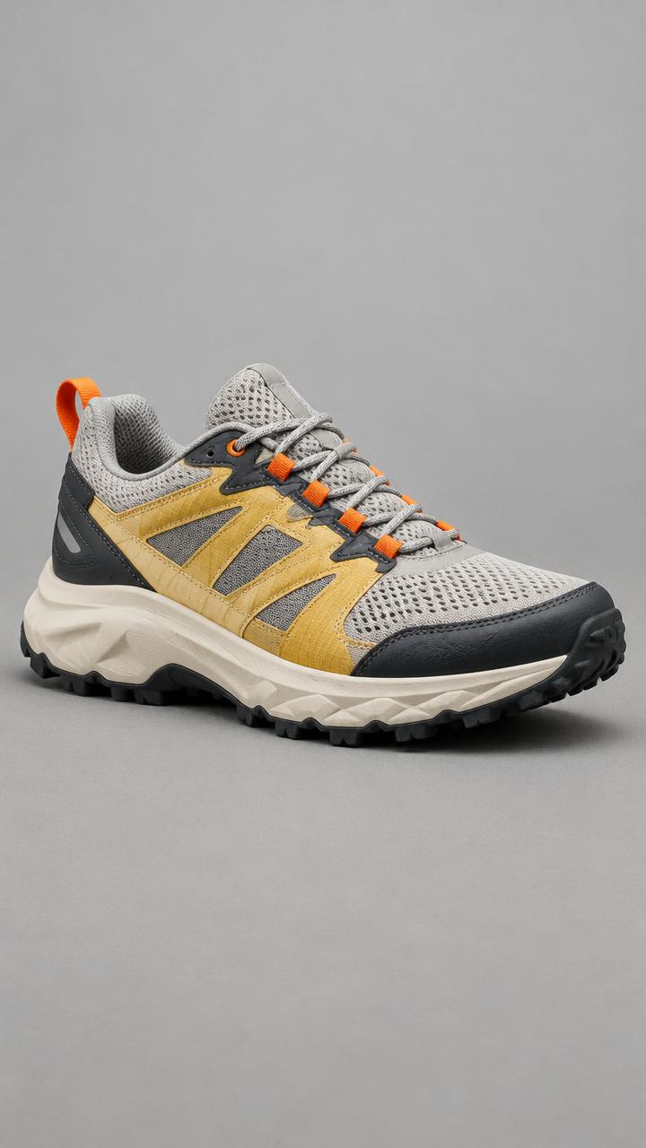 Before editing: a gray trail shoe with yellow panels and orange laces on a studio background